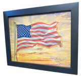 Framed artwork of an American flag against a sunset sky with a logo and text at the bottom.