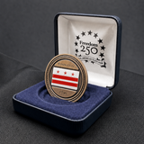 Medal with a flag design in a display case on a dark surface